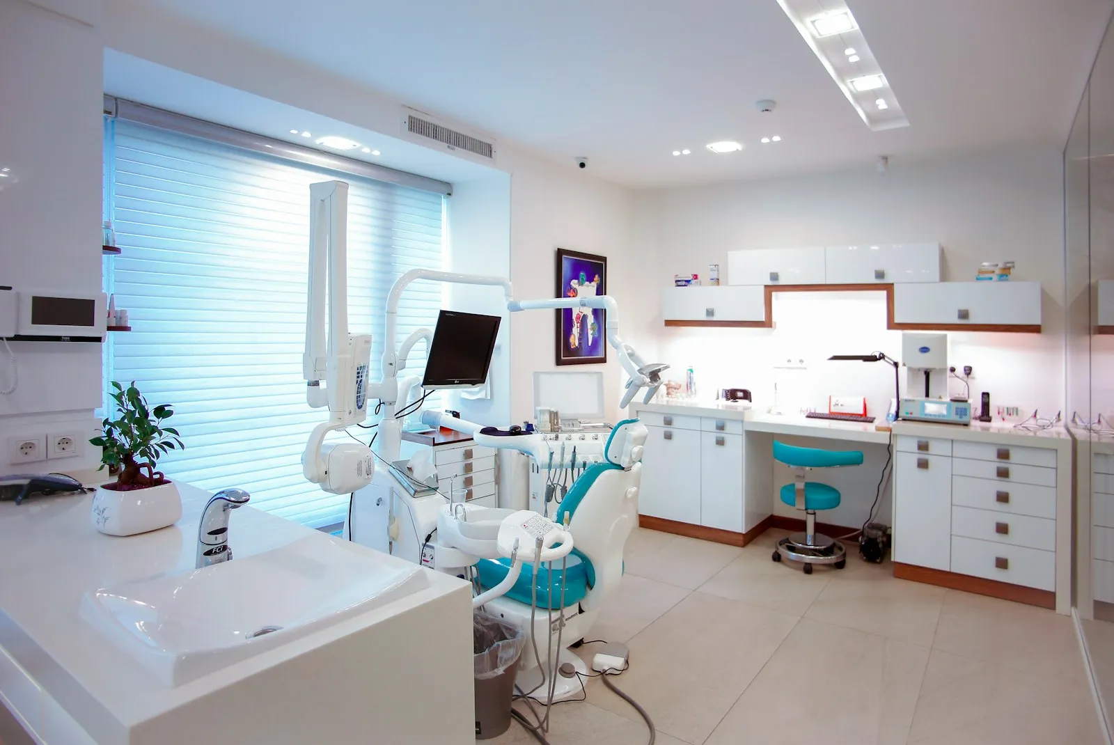 An empty, bright treatment room with a dental chair